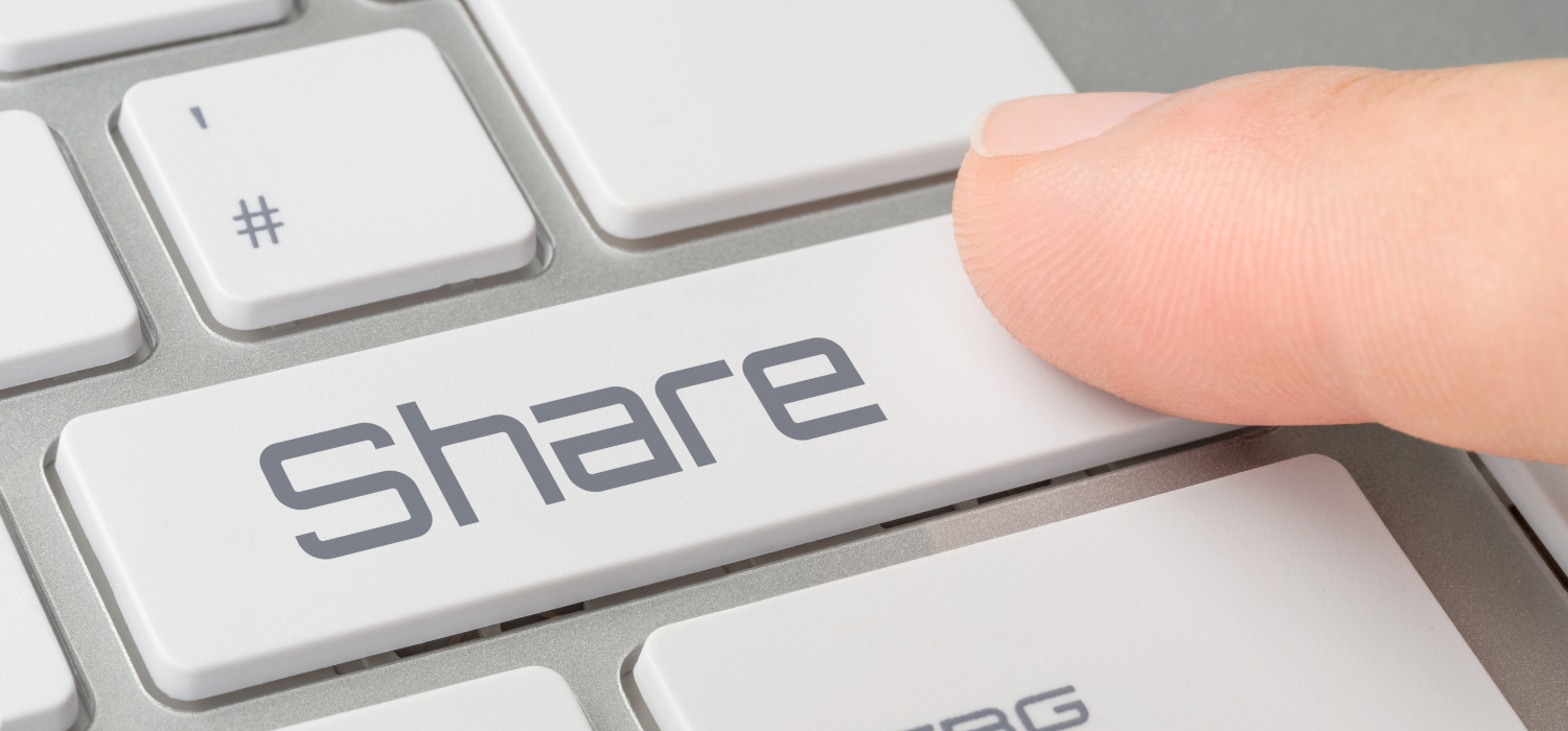 Jari menekan tombol bagikan berwarna abu-abu pada keyboard laptop untuk share konten untuk travel agency