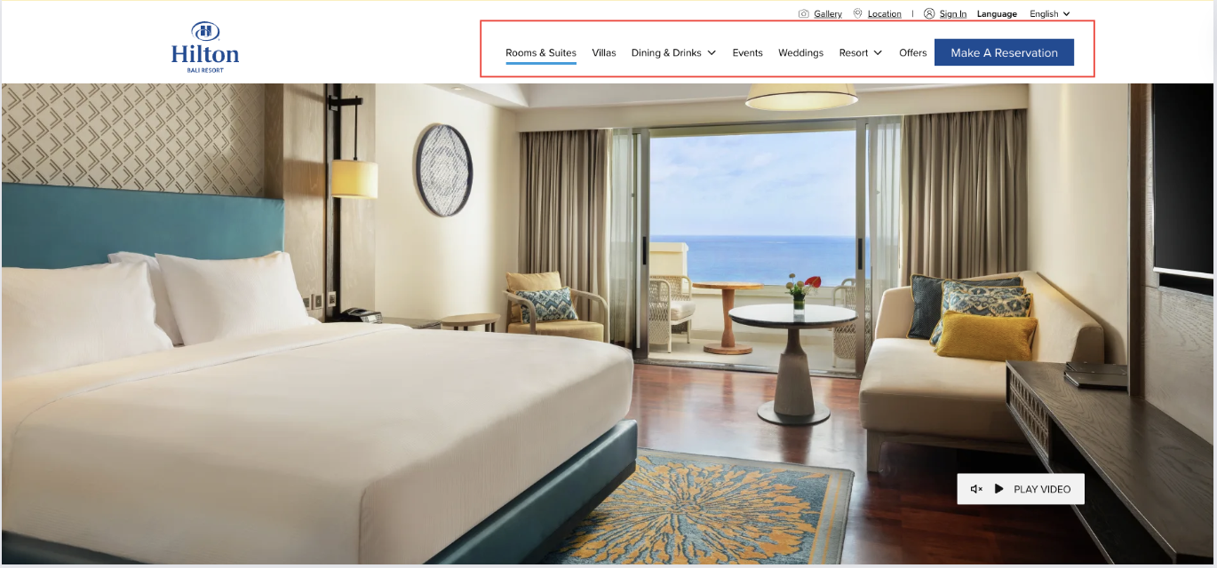 An elegant hotel room with a large bed, plush seating, and floor-to-ceiling windows offering a stunning ocean view, as displayed on Hilton's reservation website as case of Hotel booking website design.